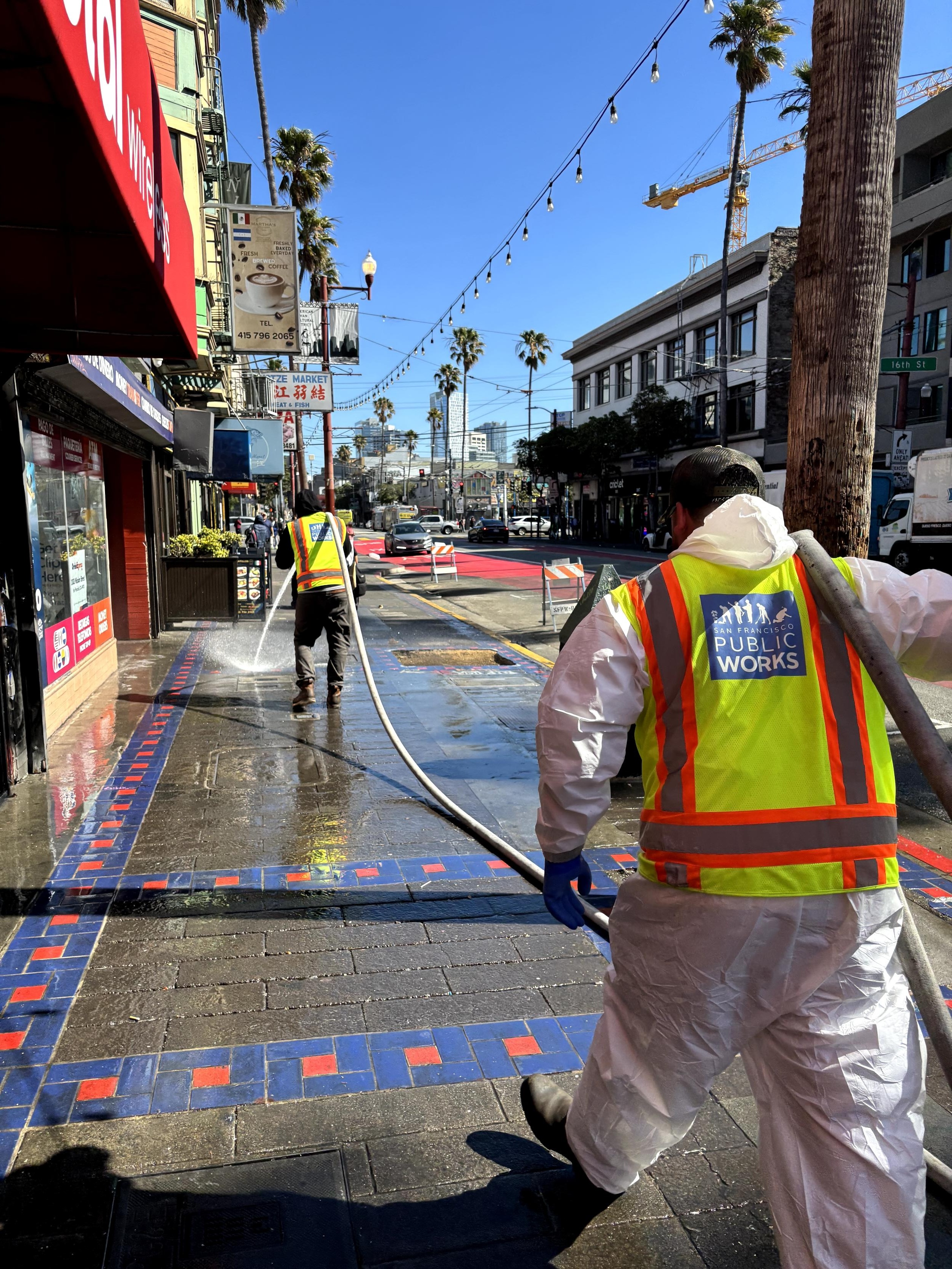 Public Works street cleaning crews power wash the Mission Street sidewalk, just south of 16th Street